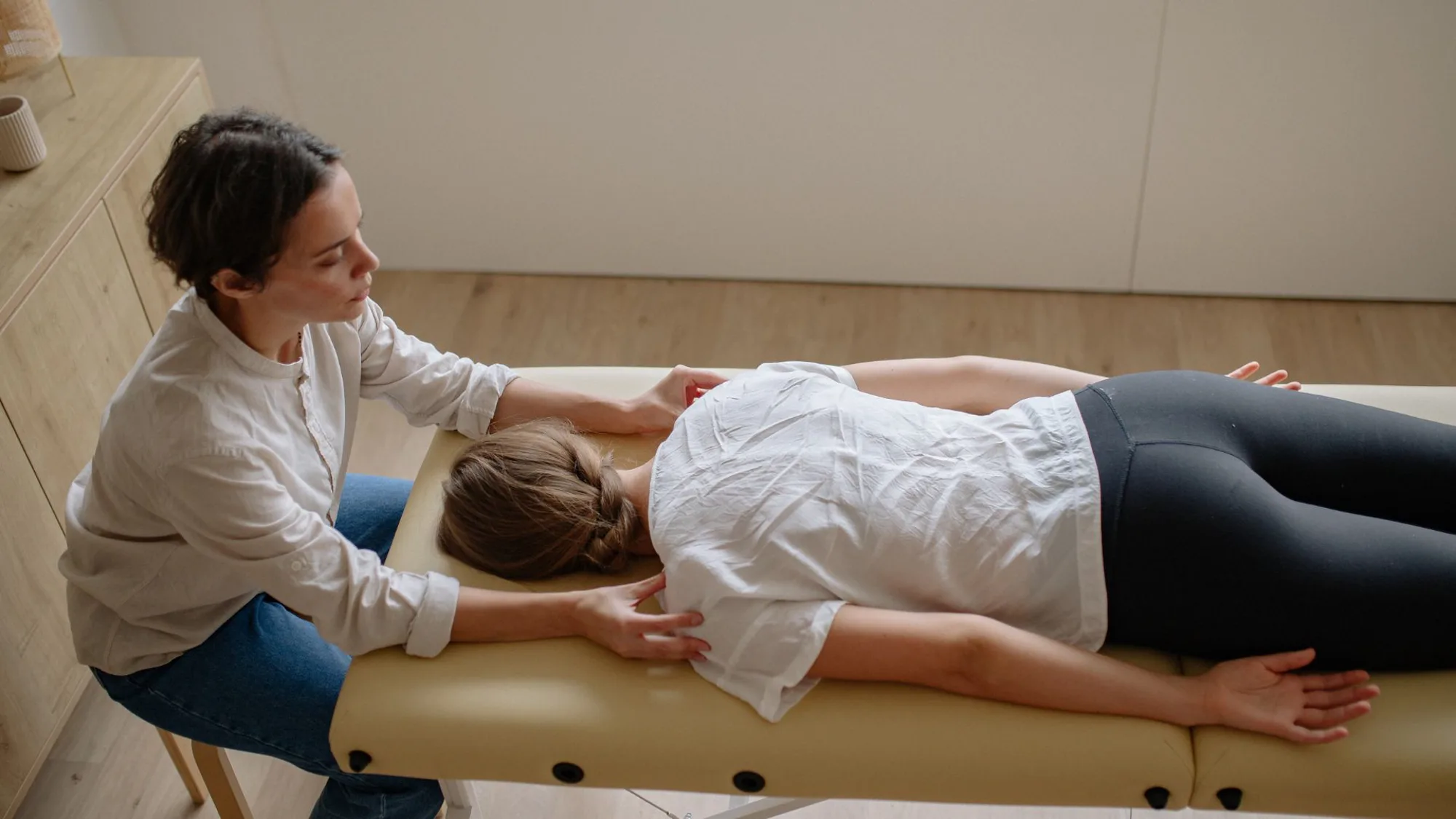 A woman relaxes as a Newmarket chiropractor provides adjustment and spinal manipulation in a tranquil setting.