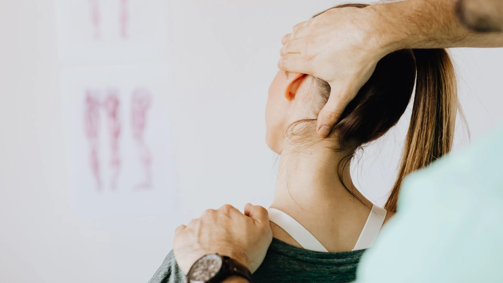 A woman receiving an osteopathy treatment from a man in a wellness clinic in Newmarket Ontario focusing on her back alignment.