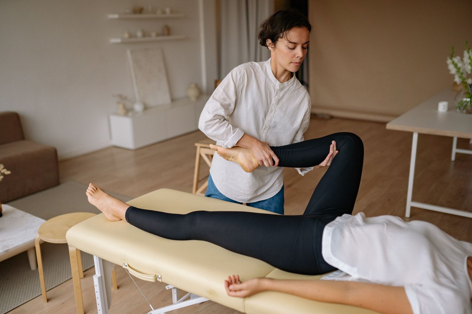 A massage therapist provides a rejuvenating leg treatment in a calming spa environment.
